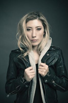 Dichen Lachman posing for a photoshoot by wearing a black leather jacket.